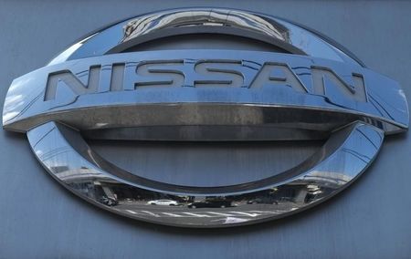 © Reuters. Cars are reflected in a Nissan Motor logo at the company's dealership in Tokyo