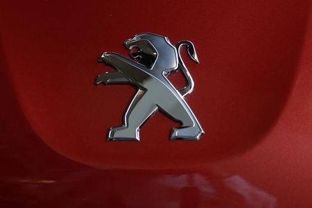 © Reuters. A Peugeot logo is seen on a car displayed at PSA Peugeot Citroen headquarters in Paris after the company's 2014 First-Half results presentation