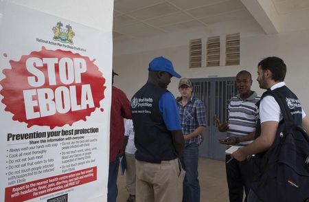 © Reuters. WHO members and health directors stand outside the Port Loko District Hospital