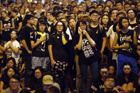 © Reuters. Protesters listen a leader of the student movement speaks to the crowd outside the government headquarters in Hong Kong