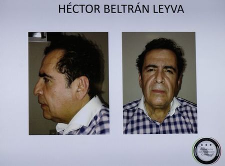 © Reuters. Pictures of head of Beltran Leyva drug cartel Hector Beltran Leyva are seen displayed on a television screen during a news conference at the Attorney General's Office building in Mexico City