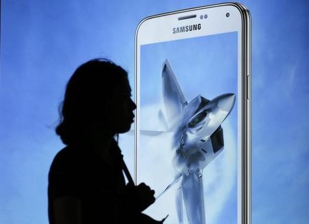 © Reuters. A woman walks past an advertisement promoting Samsung Electronics' Galaxy S5 smartphone in Seoul