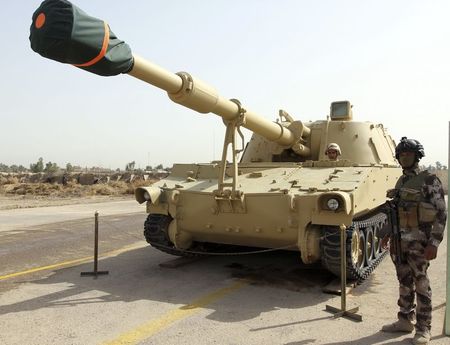 © Reuters. An Iraqi Army soldier stands near a military vehicle during a parade marking the founding anniversary of the army's artillery section in Baghdad