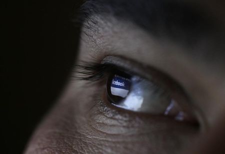 © Reuters. A picture illustration shows a man looking at the Facebook website on a tablet in Sofia