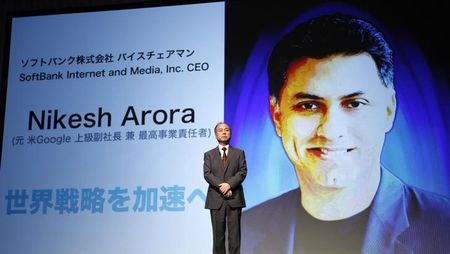 © Reuters. SoftBank Corp. Chief Executive Masayoshi Son attends a news conference as screen shows pictures of Nikesh Arora, former Google chief business officer and currently SoftBank Internet and Media, Inc.'s CEO in Tokyo