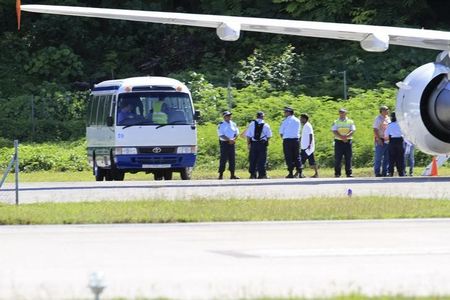 © Reuters. Asylum seekers are pictured being transported from an aircraft to a bus upon their arrival on the island of Nauru