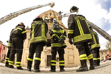 © Reuters. Firemen remove the marble statue of Madonna from the top of the church in Paganica