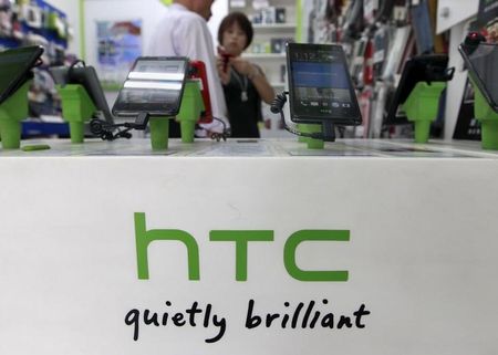 © Reuters. Customers look at HTC smartphones in a mobile phone shop in Taipei