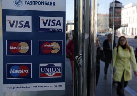 © Reuters. A sign with a logo of Gazprombank for Visa, MasterCard and Union Card is seen on the door of a shop in St. Petersburg