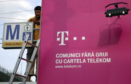 © Reuters. A worker fixes an advertising of Telekom on a metro entrance in Bucharest