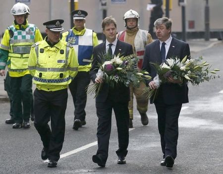 © Reuters. Britain's deputy prime minister Nick Clegg and Scottish Secretary Alistair Carmichael arrive with flowers near a helicopter crash scene in central Glasgow