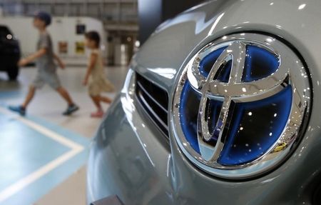 © Reuters. Visitors walk past a logo of Toyota Motor Corp in Tokyo