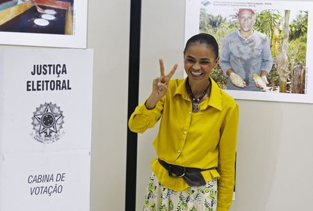 © Reuters. A candidata à Presidência Marina Silva (PSB) faz o sinal da vitória ao votar em Rio Branco (AC)