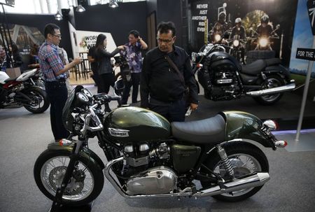 © Reuters. A visitor looks at a Triumph motorcycle on display at the Indonesian International Motor Show in Jakarta