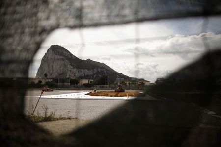 © Reuters. The rock of the British Colony of Gibraltar is seen through a hole of a fence in La Linea de la Concepcion