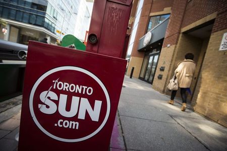 © Reuters. A woman walks by a Toronto Sun newspaper box in Toronto
