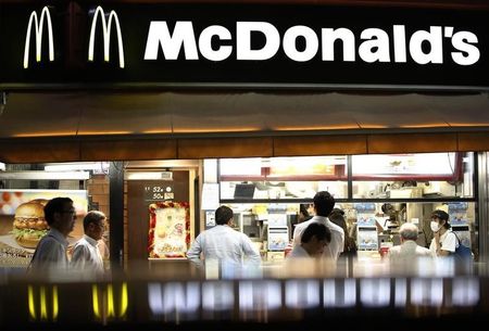 © Reuters. Passersby walk past a McDonald's store in Tokyo