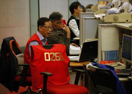 © Reuters. Floor traders chat inside the trading hall during afternoon trading at the Hong Kong Stock Exchange