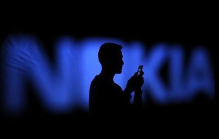 © Reuters. A photo illustration of a man silhouetted against a Nokia logo