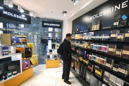 © Reuters. A man looks at Moleskine notebooks in a Moleskine store in Milan