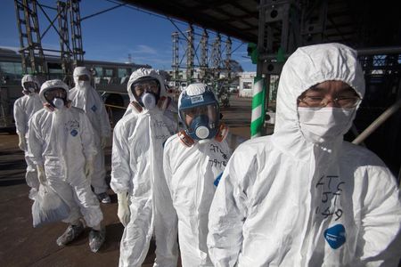 © Reuters. File photo of workers in protective suits and masks waiting to enter the emergency operation center at the crippled Fukushima Daiichi nuclear power plant in Fukushima