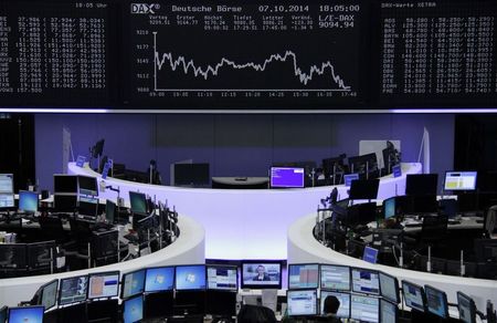© Reuters. A trader is pictured at the desk in front of the DAX board at the Frankfurt stock exchange