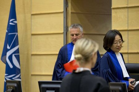 © Reuters. Presiding Judge Ozaki of Japan and Judge Fremr of the Czech Republic arrive to open the court's status hearing of Kenya's President Kenyatta at the International Criminal Court in The Hague