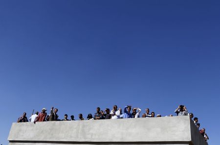 © Reuters. Curdi turchi osservano Kobani dall'alto di un palazzo al confine turco 