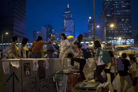 © Reuters. Protesters of the Occupy Central movement climb over a divider used by demonstrators to block the main road leading to the financial Central district in Hong Kong