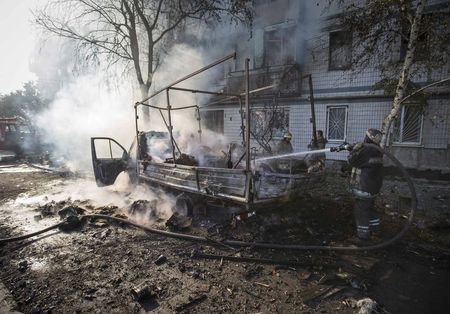 © Reuters. Bombeiros apagam fogo em veículo atingido por projétil perto do aeroporto internacional de Donetsk