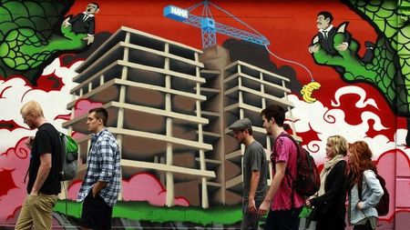 © Reuters. People walk past graffiti in Central Dublin