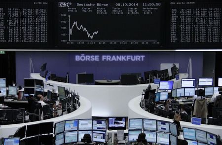 © Reuters. A trader is pictured at the desk in front of the DAX board at the Frankfurt stock exchange