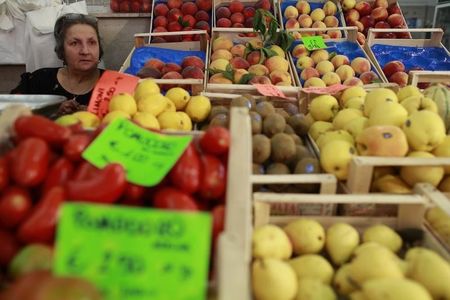 © Reuters. A fruit seller looks on in a market in downtown Rome