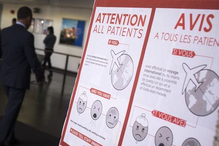 © Reuters. A sign asks patients to inform staff if they have various symptoms and have recently traveled internationally or have had contact with someone who recently traveled internationally at Bellevue Hospital in Manhattan