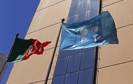 © Reuters. A Portugal Telecom flag flies beside a Portugal national flag in Lisbon