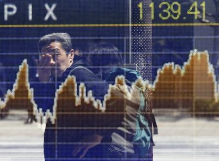 © Reuters. A man is reflected on a screen displaying a graph showing movements of the Tokyo Stock Exchange Stock Price Index (TOPIX), outside a brokerage in Tokyo