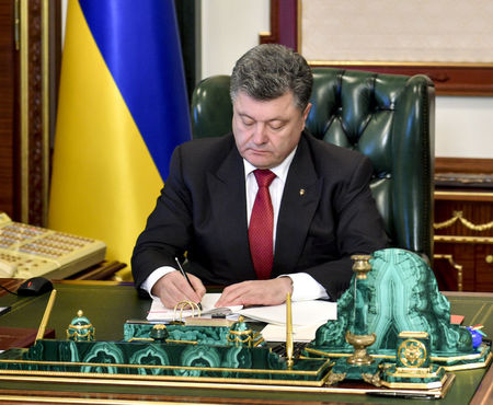 © Reuters. Ukrainian President Petro Poroshenko signs the law on "lustration" in Kiev