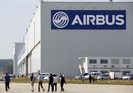 © Reuters. Airbus Group staff member walk on the tarmac near an aircraft hangar during the first flight event of the Airbus A320neo in Colomiers near Toulouse