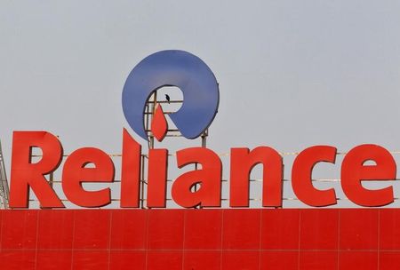 © Reuters. A crow sits a Reliance logo installed on its mart in Ahmedabad