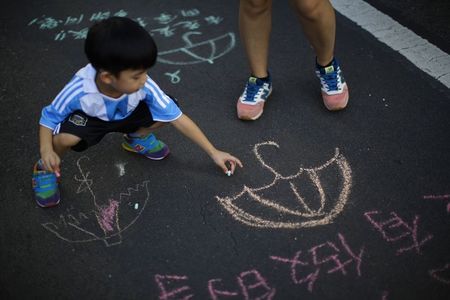 © Reuters. A boy sketches on a street blocked by pro-democracy protesters outside of the government headquarters building in Hong Kong
