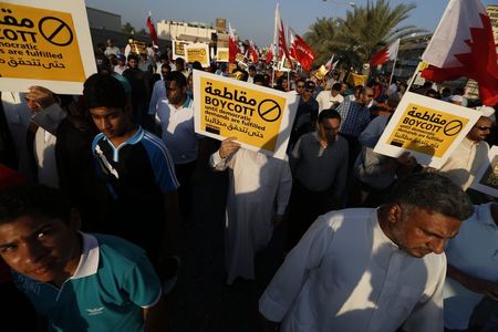 © Reuters. Protesters holding a signs march during a rally organised by Bahrain's main opposition party Al Wefaq in Budaiya