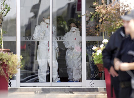 © Reuters. Medical personnel leave a quarantined hotel in Skopje