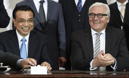 © Reuters. China's Premier Li and German Foreign Minister Frank Walter Steinmeier laugh during a signing ceremony at "The Hamburg Summit", a Chinese-German business conference, at the chamber of commerce in Hamburg