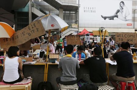 © Reuters. Pro-democracy students study on makeshift desks blocking a main road leading to the Central financial district in Hong Kong