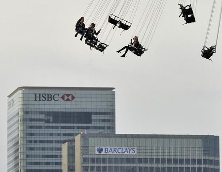 © Reuters. Financial offices of Canary Wharf are seen behind visitors to the O2 arena enjoying a fairground ride in east London