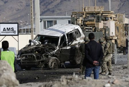 © Reuters. U.S. troops remove a damaged vehicle, which was hit by a suicide attack, in Kabul