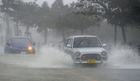 © Reuters. Carros trafegam por rua alagada depois de fortes chuvas causadas pela aproximação do tufão Vongfong, na ilha de Okinawa, Japão