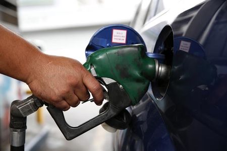 © Reuters. An employee pumps gas into a car at a PDVSA gas station in Caracas