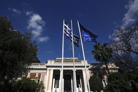 © Reuters. A Greek national flag and a EU flag wave outside the office of Greek PM Samaras in Athens