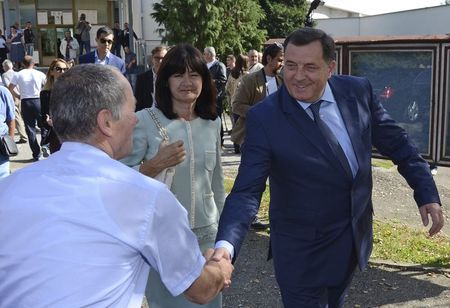 © Reuters. Dodik shakes hands with supporters after casting his ballot at a polling station in Banja Luka